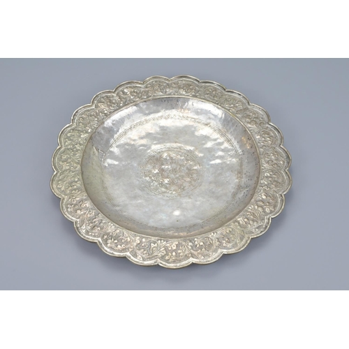 76 - An indian embossed white metal dish. diameter approx. 26cm