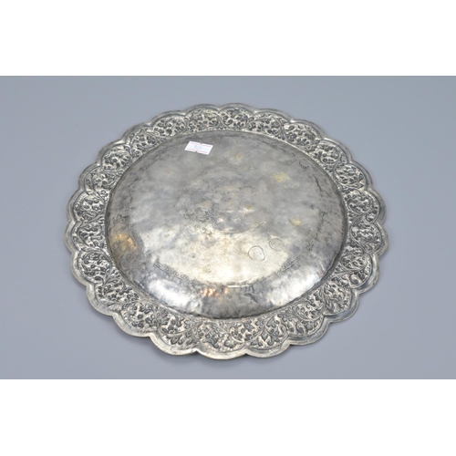 76 - An indian embossed white metal dish. diameter approx. 26cm