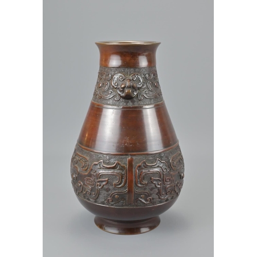 89 - A chinese bronze vase. with twin taotie mask and four character mark of wanli, height approx. 27cm