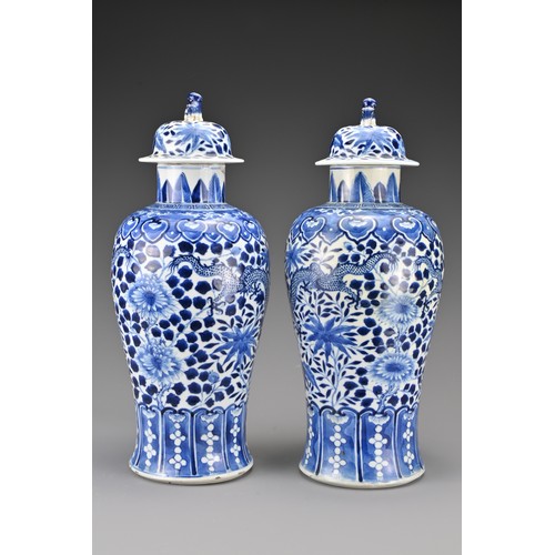 36 - A pair of Chinese 19th Century blue and white porcelain vases and covers. Decorated with four-clawed... 