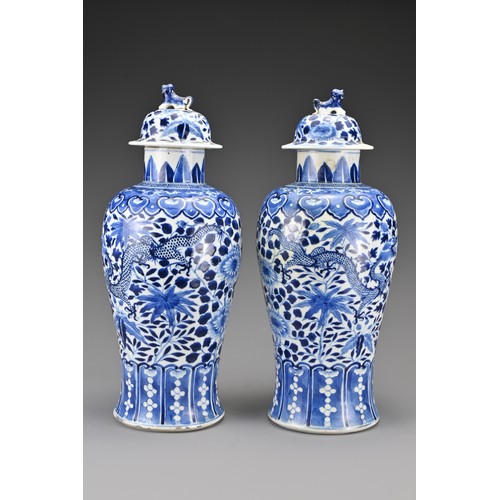 36 - A pair of Chinese 19th Century blue and white porcelain vases and covers. Decorated with four-clawed... 