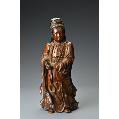 67 - A Chinese 17/18th Century carved boxwood figure of Guanyin. The figure standing with downcast eyes i... 