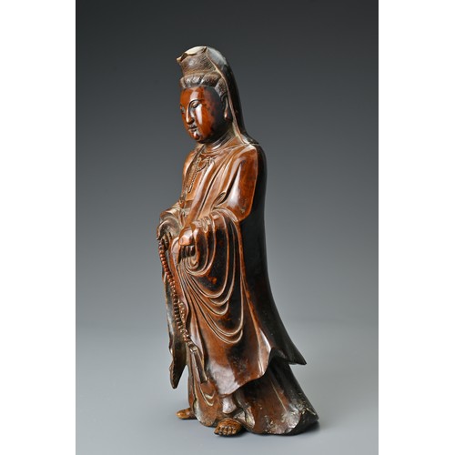 67 - A Chinese 17/18th Century carved boxwood figure of Guanyin. The figure standing with downcast eyes i... 