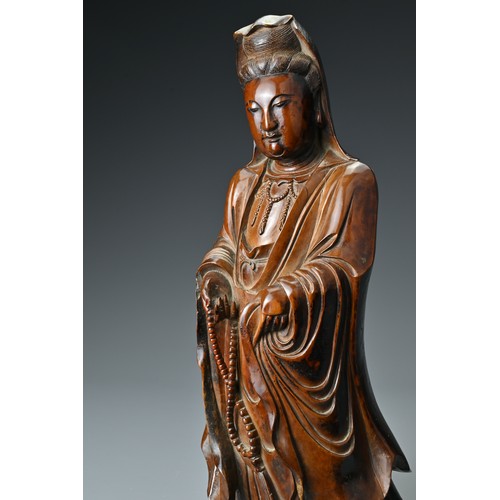 67 - A Chinese 17/18th Century carved boxwood figure of Guanyin. The figure standing with downcast eyes i... 