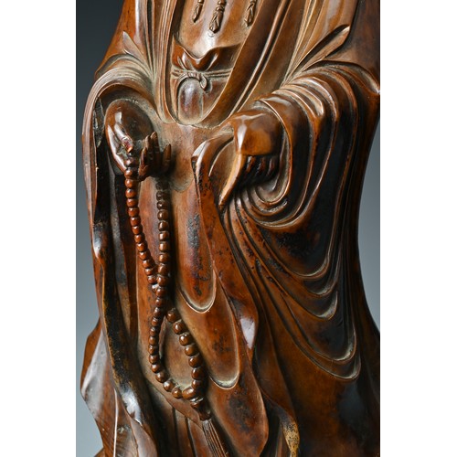 67 - A Chinese 17/18th Century carved boxwood figure of Guanyin. The figure standing with downcast eyes i... 