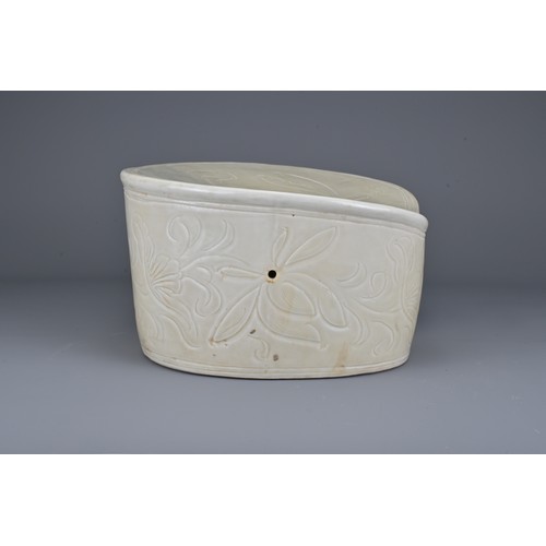 38 - A Chinese white-glazed pottery pillow with incised decoration of flowers and fish. Width approx. 24c... 