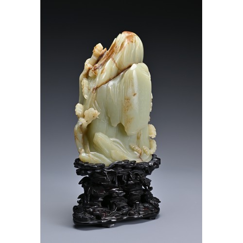 66 - A large Chinese celadon and russet jade boulder. Carved in high relief with two cranes and pine tree... 