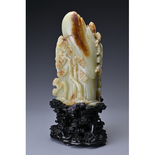 66 - A large Chinese celadon and russet jade boulder. Carved in high relief with two cranes and pine tree... 