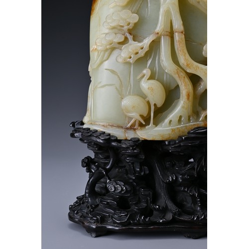 66 - A large Chinese celadon and russet jade boulder. Carved in high relief with two cranes and pine tree... 