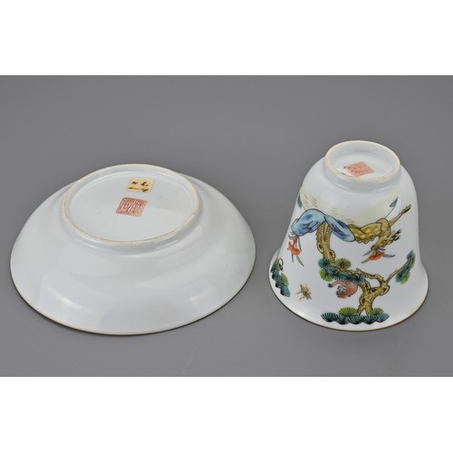 80 - A Chinese porcelain enamelled cup and saucer. Painted with a monkey in a pine tree with deer holding... 