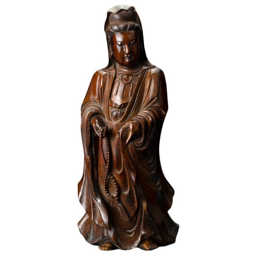 67 - A Chinese 17/18th Century carved boxwood figure of Guanyin. The figure standing with downcast eyes i... 