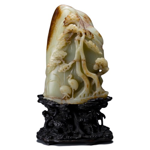 66 - A large Chinese celadon and russet jade boulder. Carved in high relief with two cranes and pine tree... 