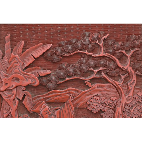 6 - A CHINESE CINNABAR LACQUER PANEL, 19TH CENTURY. Well carved in relief with scholar figures in a land... 