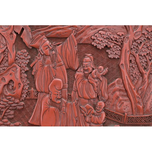 6 - A CHINESE CINNABAR LACQUER PANEL, 19TH CENTURY. Well carved in relief with scholar figures in a land... 