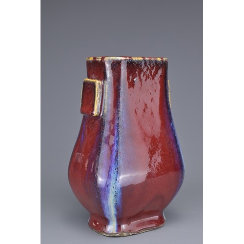 15 - A CHINESE FLAMBE GLAZED HU VASE. With flat rectangular handles covered in a reddish purple glaze wit... 