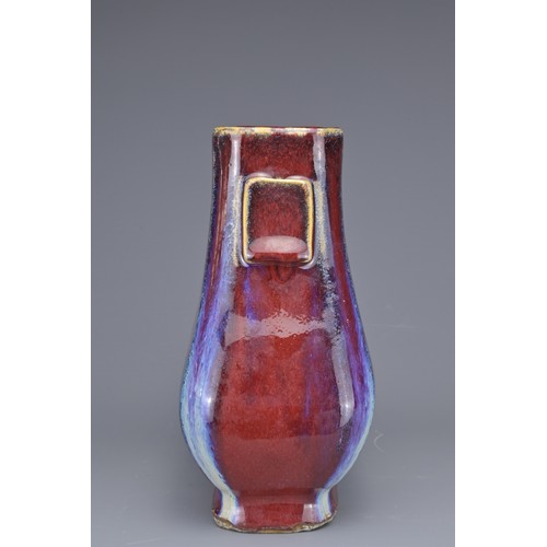 15 - A CHINESE FLAMBE GLAZED HU VASE. With flat rectangular handles covered in a reddish purple glaze wit... 