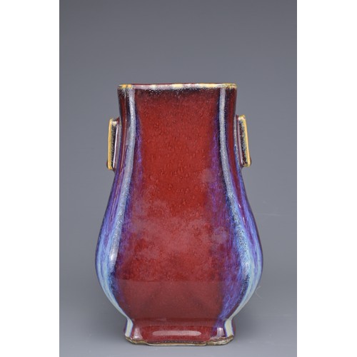 15 - A CHINESE FLAMBE GLAZED HU VASE. With flat rectangular handles covered in a reddish purple glaze wit... 