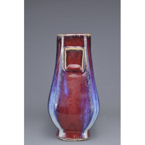 15 - A CHINESE FLAMBE GLAZED HU VASE. With flat rectangular handles covered in a reddish purple glaze wit... 