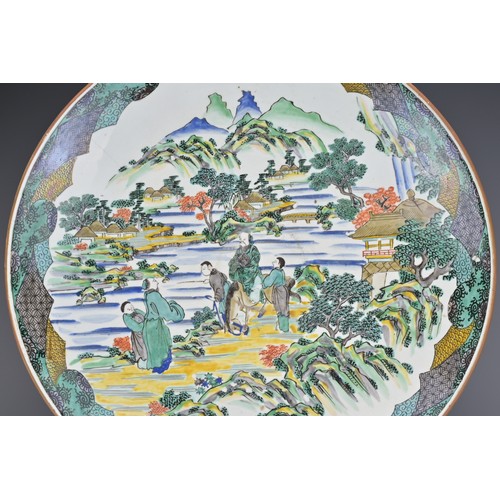 23 - A JAPANESE KUTANI WARE CERAMIC CHARGER. Decorated in polychrome enamels depicting a figure on horseb... 