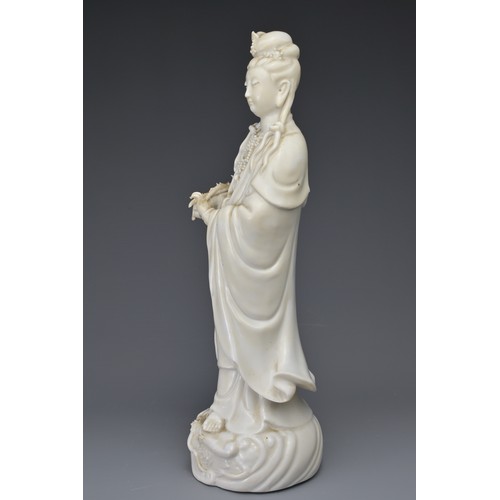 29 - A CHINESE BLANC DE CHINE FIGURE OF GUANYIN. The moulded figure of Guanyin standing on a dragon cover... 