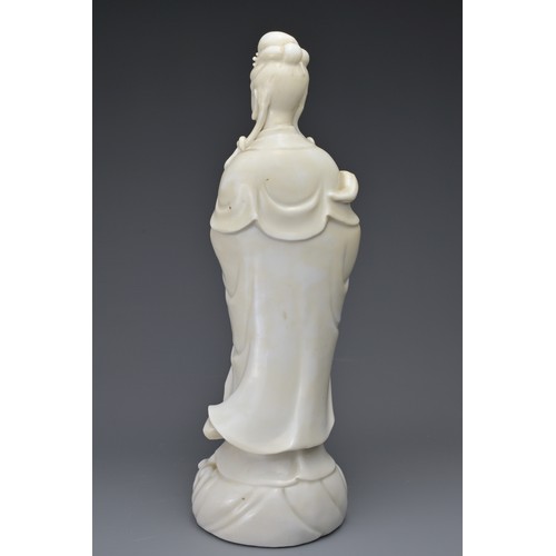 29 - A CHINESE BLANC DE CHINE FIGURE OF GUANYIN. The moulded figure of Guanyin standing on a dragon cover... 