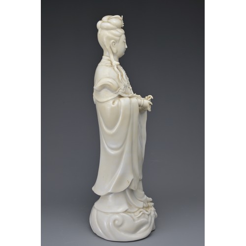 29 - A CHINESE BLANC DE CHINE FIGURE OF GUANYIN. The moulded figure of Guanyin standing on a dragon cover... 