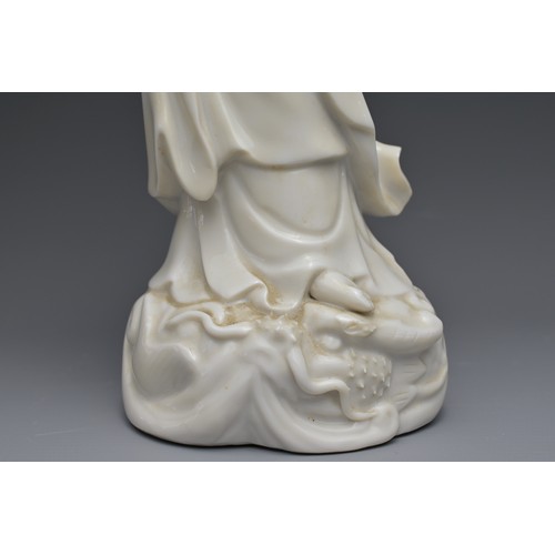 29 - A CHINESE BLANC DE CHINE FIGURE OF GUANYIN. The moulded figure of Guanyin standing on a dragon cover... 