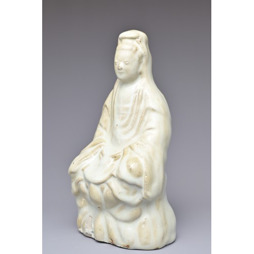 32 - A CHINESE CERAMIC FIGURE OF GUANYIN. The figure seated on a lotus base covered in a pale bluish whit... 