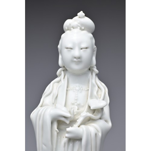 33 - A CHINESE BLANC DE CHINE PORCELAIN FIGURE OF GUANYIN, 18TH CENTURY. The figure standing on a lotus w... 