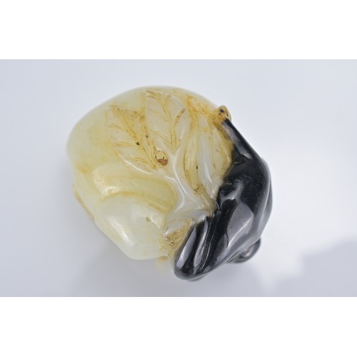 58 - A CHINESE PALE CELADON AND BLACK JADE PENDANT OF MONKEY ON PEACH. Approx. 4cm length.