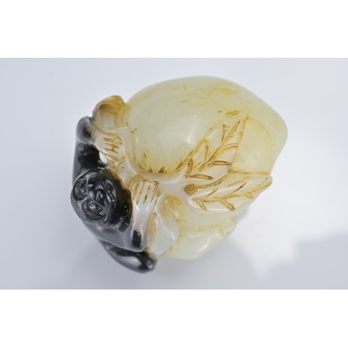 58 - A CHINESE PALE CELADON AND BLACK JADE PENDANT OF MONKEY ON PEACH. Approx. 4cm length.