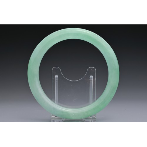 59 - A CHINESE JADEITE CYLINDRICAL BANGLE. Outer diameter 8.7cm. Inner diameter 6.7cm. Thickness approx. ... 