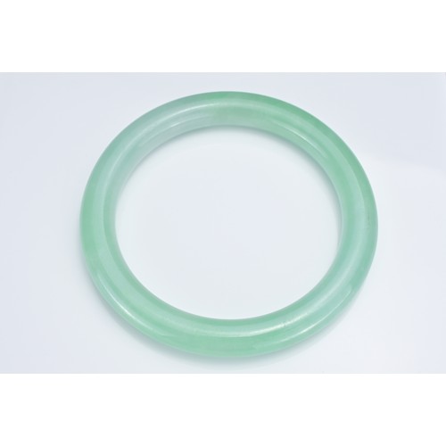 59 - A CHINESE JADEITE CYLINDRICAL BANGLE. Outer diameter 8.7cm. Inner diameter 6.7cm. Thickness approx. ... 