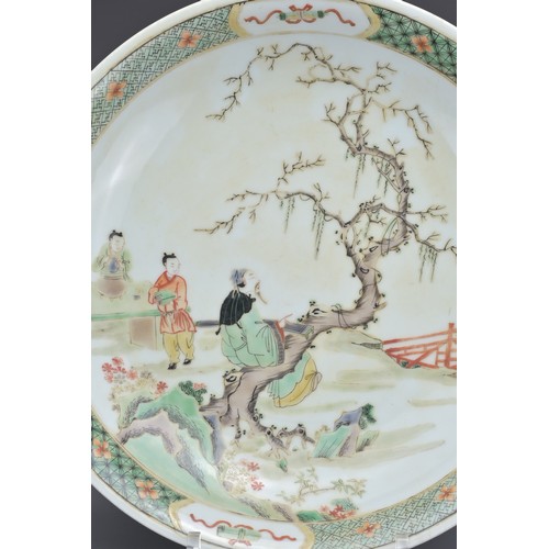 68 - A CHINESE FAMILLE VERTE PORCELAIN DISH. Depicting a garden scene with figure sat on a tree playing t... 