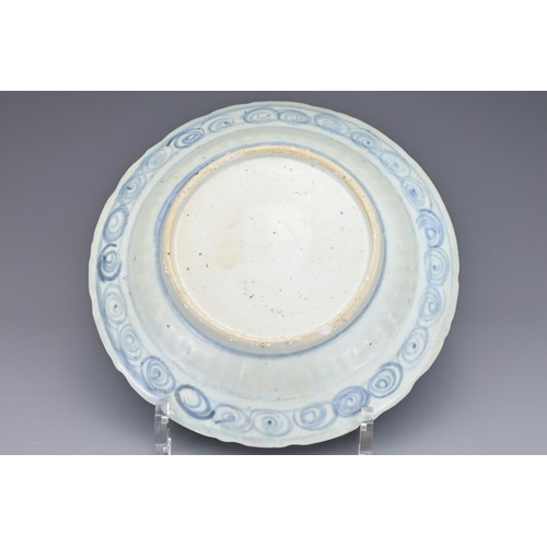 74 - A CHINESE BLUE AND WHITE PORCELAIN DISH, MING DYNASTY. Barbed rim and ribbed body decorated with qil... 