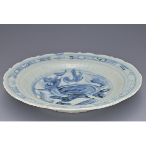 74 - A CHINESE BLUE AND WHITE PORCELAIN DISH, MING DYNASTY. Barbed rim and ribbed body decorated with qil... 