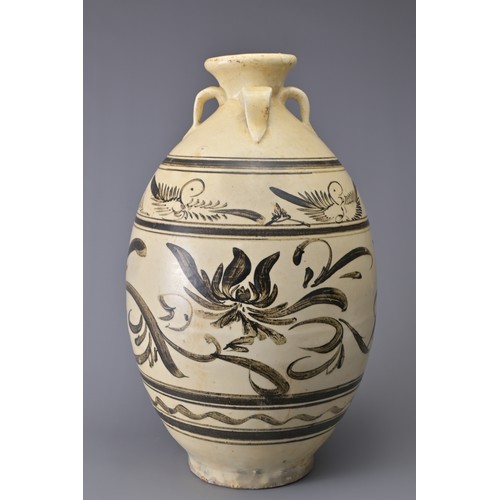 99 - A TALL CHINESE CIZHOU STONEWARE JAR. With four loop handles at the shoulder and decorated in iron-br... 