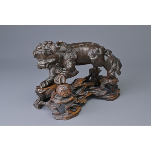 25 - A CHINESE BRONZE MODEL OF DOG OF FO, 18/19TH C. ON WOODEN STAND. The figure heavily cast standing on... 