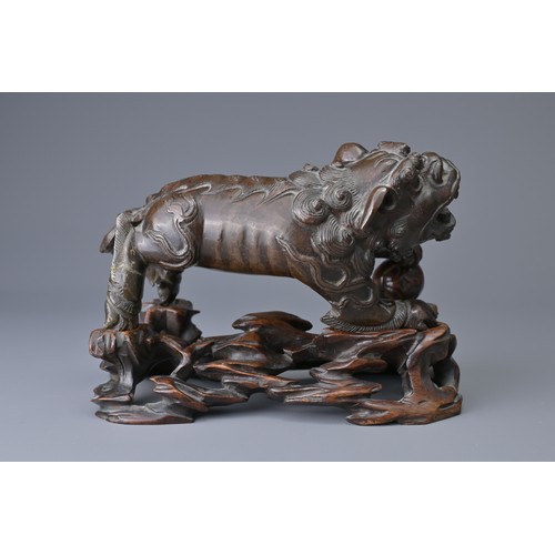 25 - A CHINESE BRONZE MODEL OF DOG OF FO, 18/19TH C. ON WOODEN STAND. The figure heavily cast standing on... 