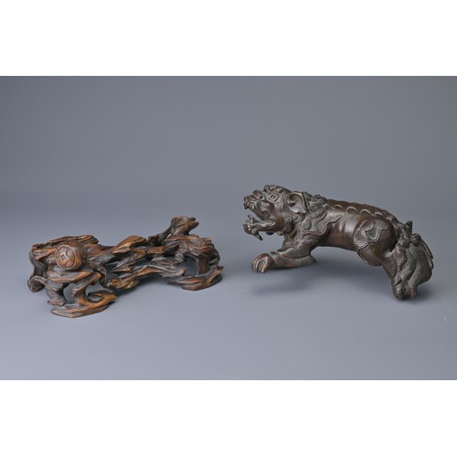 25 - A CHINESE BRONZE MODEL OF DOG OF FO, 18/19TH C. ON WOODEN STAND. The figure heavily cast standing on... 