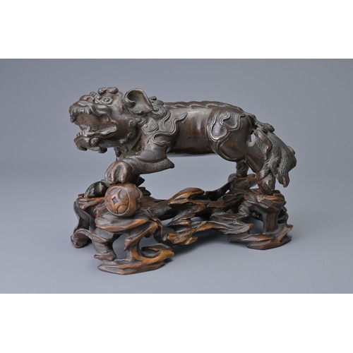 25 - A CHINESE BRONZE MODEL OF DOG OF FO, 18/19TH C. ON WOODEN STAND. The figure heavily cast standing on... 