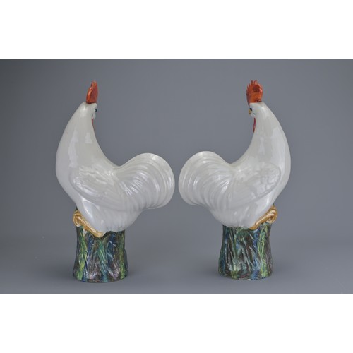 90 - PAIR OF CHINESE EXPORT PORCELAIN MODELS OF ROOSTERS, EARLY 20TH CENTURY. A mirrored pair standing on... 