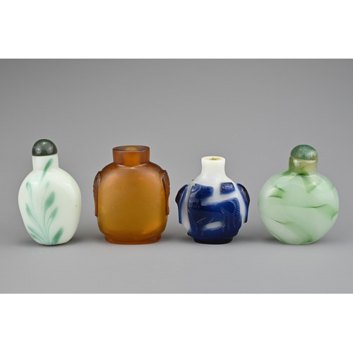 2 - FOUR CHINESE SNUFF BOTTLES. Comprising an amber-coloured glass bottle with two mask and ring handles... 