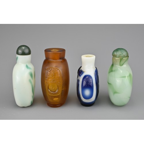 2 - FOUR CHINESE SNUFF BOTTLES. Comprising an amber-coloured glass bottle with two mask and ring handles... 