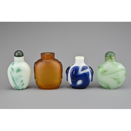 2 - FOUR CHINESE SNUFF BOTTLES. Comprising an amber-coloured glass bottle with two mask and ring handles... 