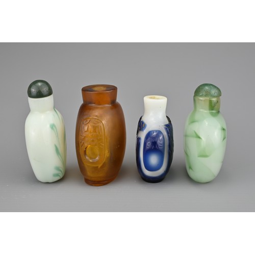 2 - FOUR CHINESE SNUFF BOTTLES. Comprising an amber-coloured glass bottle with two mask and ring handles... 