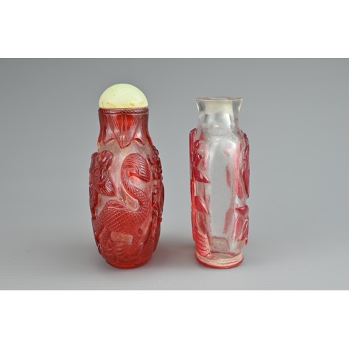 6 - TWO CHINESE GLASS SNUFF BOTTLES. To include a red-overlay glass bottle with dragons and green stone ... 