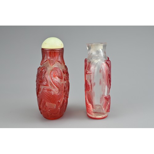 6 - TWO CHINESE GLASS SNUFF BOTTLES. To include a red-overlay glass bottle with dragons and green stone ... 