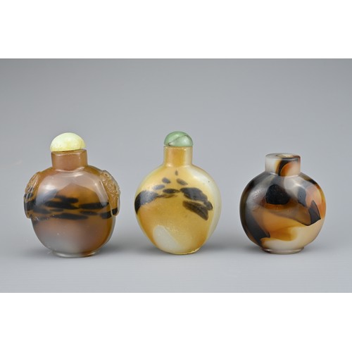 9 - THREE CHINESE SNUFF BOTTLES. Comprising two agate bottles with green stone stoppers, one with caved ... 