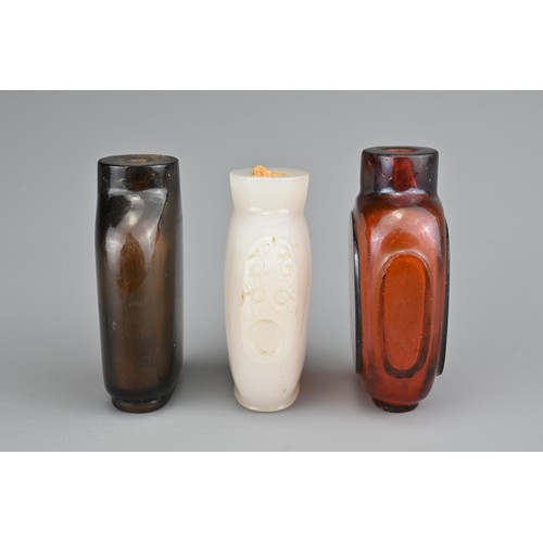 12 - THREE CHINESE COLOURED GLASS SNUFF BOTTLES. Each of various forms. 5-5.5cm tall. (3)

Provenance: Pr... 